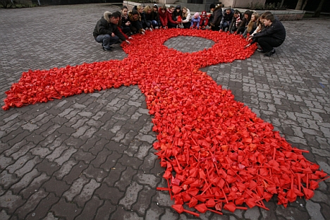 Activists form a red ribbon, the symbol of the worldwide campaign against AIDS, made from paper tulips as they take part in the campaign and also mark International Volunteers' Day in the city of Rostov-on-Don